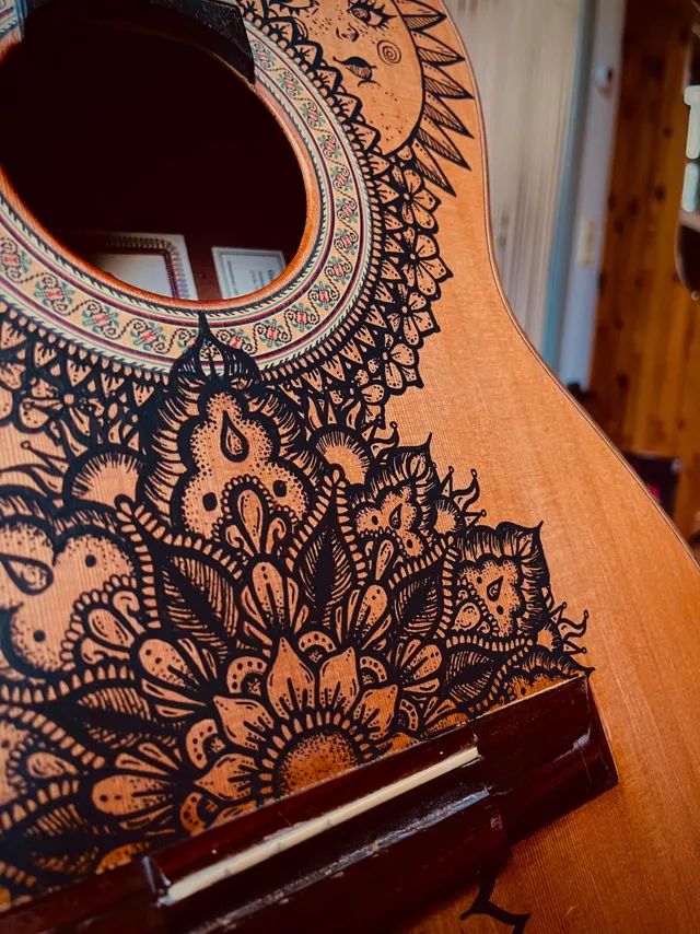 Guitar hand-drawn with mandala flowers and a sun face