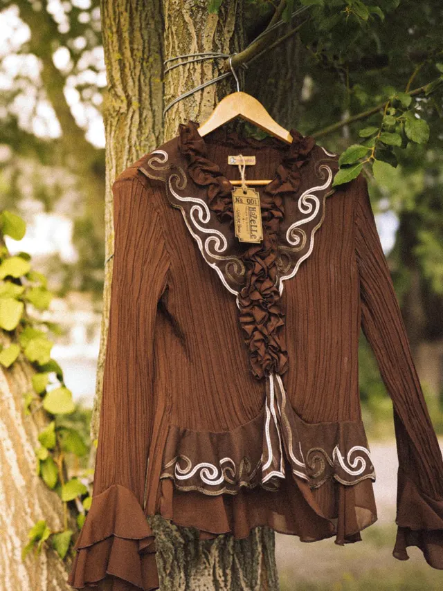 Brown ruffle blouse hanging from a tree